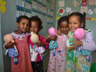 girls-holding-dolls-in-kindergarten-classroom.jpg