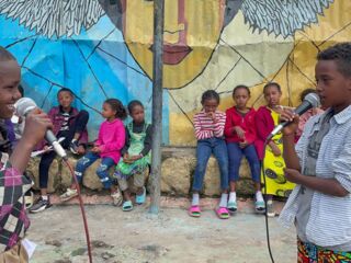 Children performing with mics